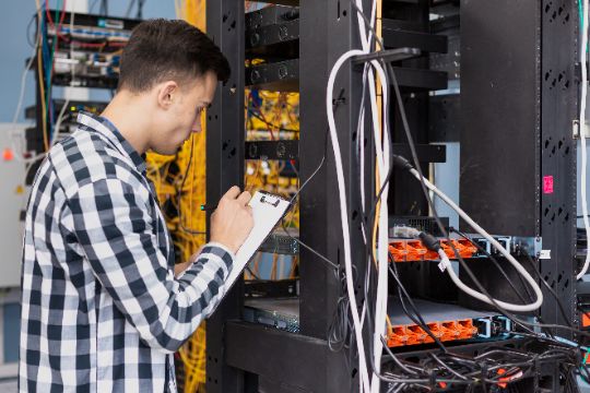 Joven ingeniero haciendo chequeo de servidores
